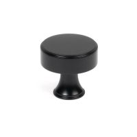 The 38mm "Atelier" Circular Cabinet Knob in Matt Black on a White Background Stood Upright 