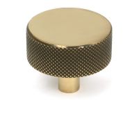 The 38mm "Vesper" Knurled Edge Cabinet Knob in Aged Brass on a White Background Shown Stood Upright 