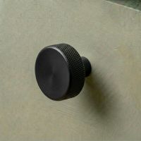The 38mm "Vesper" Knurled Edge Cabinet Knob in Matt Black for Kitchen Cupboards on na Green Drawer - Digital Illustration The 38mm "Vesper" Knurled Edge Cabinet Knob in Matt Black for Kitchen Cupboards on na Green Drawer - Digital Illustration