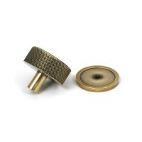 The 38mm Knurled Cabinet Knob on a Plain Rose in Aged Brass Shown from Behind on a White Background The 38mm Knurled Cabinet Knob on a Plain Rose in Aged Brass Shown from Behind on a White Background