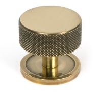 The 38mm Knurled Cabinet Knob on a Plain Rose in Aged Brass Shown Upright on a White Background The 38mm Knurled Cabinet Knob on a Plain Rose in Aged Brass Shown Upright on a White Background