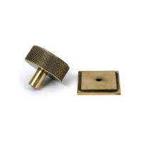 The 38mm Knurled Cabinet Knob on a Square Rose in Aged Brass Shown from Behind on a White Background The 38mm Knurled Cabinet Knob on a Square Rose in Aged Brass Shown from Behind on a White Background
