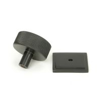 The 38mm Knurled Cabinet Knob on a Square Rose in Aged Bronze Shown from Behind on a White Background