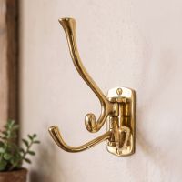 A Close up of the 3 Prong Brass "Swivel" Hook Mounted on a Cream Wall - Digital Illustration A Close up of the 3 Prong Brass "Swivel" Hook Mounted on a Cream Wall - Digital Illustration