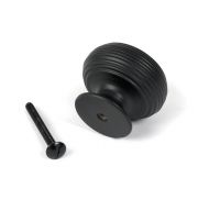 The 40mm "Garrison" Ribbed Beehive Knob in Matt Black on a White Background Shown from Behind with the Screw