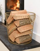 The 41cm Brass Plated Wire Log Basket adjacent to Lit Log Burner Stove in a Modern Home - Digital Illustration 
