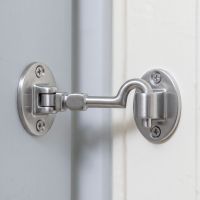The 4 Inch Satin Chrome Brass Cabin Hooks Silent Type on a White Door Being Held Open - Digital Illustration 