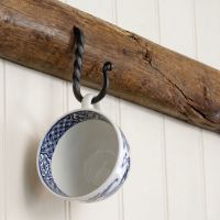 The 51mm Blacksmith Black Cup Hook Fitted on a Wooden Beam with a Tea cup hanging From it - Digital Illustration The 51mm Blacksmith Black Cup Hook Fitted on a Wooden Beam with a Tea cup hanging From it - Digital Illustration