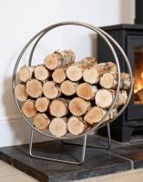 The 69.5cm Pewter Finish Circular Log Rack & Holder Shown up Close next to a Traditional Log Burner Stove - Digital Illustration The 69.5cm Pewter Finish Circular Log Rack & Holder Shown up Close next to a Traditional Log Burner Stove - Digital Illustration