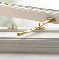 The 8" Satin Brass Three Pin Window Stay Mounted on a Wooden Window Frame - Digital Illustration The 8" Satin Brass Three Pin Window Stay Mounted on a Wooden Window Frame - Digital Illustration