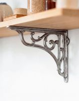 The 9 x 10cm Decorative Cast Iron Shelf Bracket with Scroll Displayed in. a Modern Home to Support Wooden Shelving - Digital Illustration 