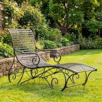 The "Windsor" Scrollwork Wrought Iron Sun Lounger in a Black Finish Positioned on a Sunny Garden Lawn - Digital Illustration The "Windsor" Scrollwork Wrought Iron Sun Lounger in a Black Finish Positioned on a Sunny Garden Lawn - Digital Illustration