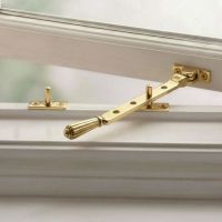 The Aged Brass Georgian Reeded Casement Window Stay on a White Window Frame - Digital Illustration The Aged Brass Georgian Reeded Casement Window Stay on a White Window Frame - Digital Illustration