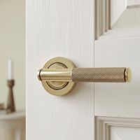 The Aged Brass Knurled Lever on Plain Rose Set on a Classic White Door in a Modern Home Interior - Digital Illustration