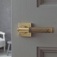 The Aged Brass Knurled Lever on Square Rose Set on a Grey Door in a Modern Interior Setting - Digital Illustration