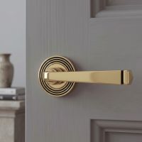 The Aged Brass Tapered Lever on Beehive Rose Set on a Grey Door in a Cosy Ho,e Setting - Digital Illustration