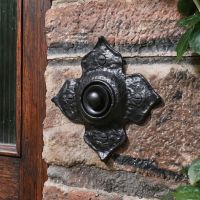 The Antique Black Iron Flower Design Front Door Bell Push next to a Front Door on a Country Home - Digital Illustration 