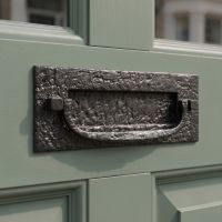 The Antique Black Iron Front Door Letter Plate With Integral Knocker on a Sage Coloured Wooden Door - Digital Illustration The Antique Black Iron Front Door Letter Plate With Integral Knocker on a Sage Coloured Wooden Door - Digital Illustration