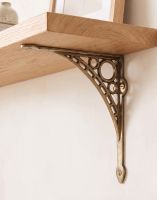 The Antique Brass 20cm x 22cm "Iron Bridge" Shelf Bracket Mounted on a Cream Coloured Living Room Wall - Digital Illustration