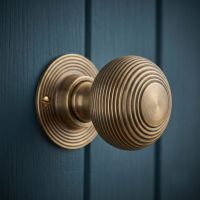 The Antique Brass Beehive Door Knob Set Fitted on a Dark Blue Panelled Door - Digital Illustration The Antique Brass Beehive Door Knob Set Fitted on a Dark Blue Panelled Door - Digital Illustration