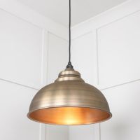 The Arcus Spun Pendant Light in Aged Brass Shown Lit up from a Low Angle
