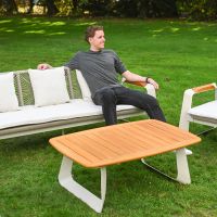 The Arcus Woven Rope Lounge Suite With a Man Relaxing on the Sofa on a Garden Lawn
