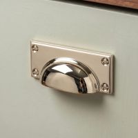 The Art Deco Cup Drawer Pull with Backplate in Polished Nickel Mounted on a Cupboard in a Contemporary Kitchen Shown Close up - Digital Illustration The Art Deco Cup Drawer Pull with Backplate in Polished Nickel Mounted on a Cupboard in a Contemporary Kitchen Shown Close up - Digital Illustration