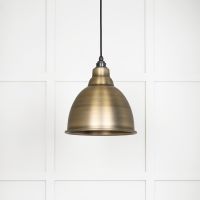The Aura Dome Pendant Light in Aged Brass Shown with the Light off on a White Panelled Background