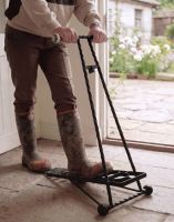The Black Glenmore Boot Jack Shown Being Used on a Traditional Stone Tile Entrance Porch - Digital Illustration 