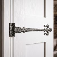 The Black Iron Fleur-De-Lys Hinge Pair Shown in a Modern Home.on a White Door - Digital Illustration