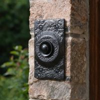 The Black Iron Square Bell Push on a Granite Stone Wall next to a House Front Entrance - Digital Illustration 
