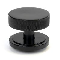 The Black Knurled Centre Door Knob on an Art Deco Rose Shown Upright on a White Background 