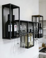 The Black Rustic Industrial Cage Wall Mounted Wine Cabinet Fitted on a Modern White Kitchen Wall with a Selection of Wine Bottles on Display - Digital Illustration