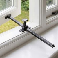 The Black Screw Adjusted Casement Stay Fitted on a White Window Frame - Digital Illustration The Black Screw Adjusted Casement Stay Fitted on a White Window Frame - Digital Illustration