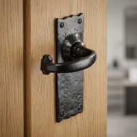 The Black Wide Backplate Scalloped Lever Latch Door Handle on a Light Wooden Door Leading to a Modern Living Room Setting - Digital Illustration 