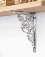 The Bright Chrome Trellis Shelf Bracket in Two Sizes Mounted on a White Coloured Interior Living Room Wall - Digital Illustration 