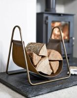 The Bronze Steel & Brown Leather Log Holder on a Black Stone Hearth next to a Modern Log Burner Stove in a Modern Home - Digital Illustration The Bronze Steel & Brown Leather Log Holder on a Black Stone Hearth next to a Modern Log Burner Stove in a Modern Home - Digital Illustration