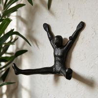 The Cast Iron "Star Jump" Coat Hook `Displayed on a Textured Cream Wall - Digital Illustration