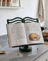 The Cast Iron Cook Book Stand in Green Holding a Recipe Book in a Decorative Kitchen - Digital Illustration