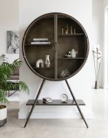 The Circular Industrial Freestanding Cabinet In a Modern Home Displaying Ornaments and Books - Digital Illustration The Circular Industrial Freestanding Cabinet In a Modern Home Displaying Ornaments and Books - Digital Illustration