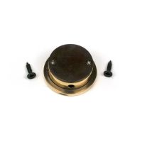 The Circular Pocket Door Edge Pull in Aged Brass Shown from Behind with Screws