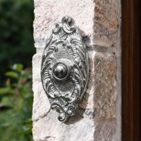The Clarice Oval Bright Chrome Ornate Bell Push on a Country Cottage Exterior Wall - Digital Illustration The Clarice Oval Bright Chrome Ornate Bell Push on a Country Cottage Exterior Wall - Digital Illustration