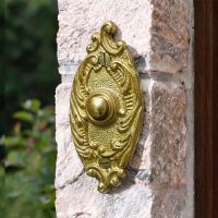 The Clarice Oval Polished Brass Ornate Bell Push by a Front Door of a Country Home - Digital Illustration The Clarice Oval Polished Brass Ornate Bell Push by a Front Door of a Country Home - Digital Illustration