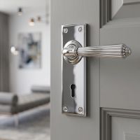 The Classic Fluted Period Lever Lock Suite Architectural Door Handle Set in Polished Chrome on a Door Leading to a Modern Living Room - Digital Illustration 