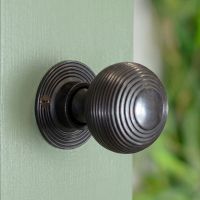 The Dark Bronze Beehive Door Knob Set Mounted on a Sage Green Door in a Modern Home - Digital Illustration 