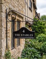 The Double Sided Classic Black House Name Sign with Vinyl Lettering Mounted on a Country Cottage - Digital Illustration The Double Sided Classic Black House Name Sign with Vinyl Lettering Mounted on a Country Cottage - Digital Illustration