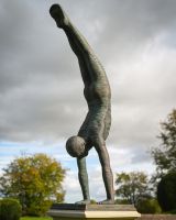 The Equilibrium Handstand Garden Sculpture in Verdigris Displayed as a Garden Centrepiece