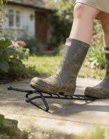 The Hampton Traditional Boot Jack Shown Being Used on a Sunny Garden Patio - Digital Illustration 