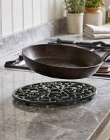 The Heavy Duty Oval Green Trivet next to a Cast Iron Pan - Digital Illustration The Heavy Duty Oval Green Trivet next to a Cast Iron Pan - Digital Illustration