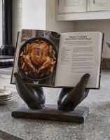The Helping Hands Cookbook Stand on a Marble Effect Kitchen Top Holding a Recipe Book Open - Digital Illustration The Helping Hands Cookbook Stand on a Marble Effect Kitchen Top Holding a Recipe Book Open - Digital Illustration